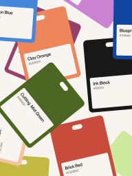 Colorful rectangular color swatch cards labeled with shade names and hex codes scattered across a plain background.