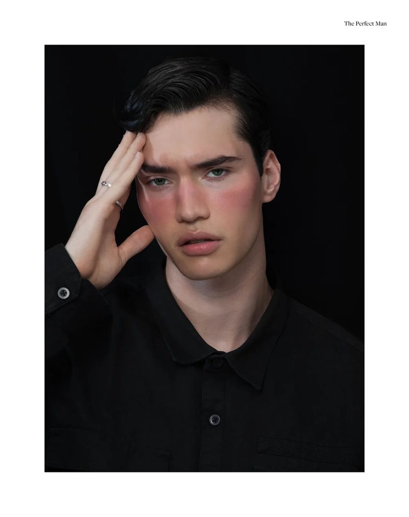 Model Gabo Dos Santos posing with hand on his temple wearing a black button-down shirt against a plain black background.