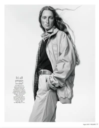 Black and white fashion portrait of a model wearing an oversized blouson jacket, polo shirt, and belted chinos on a white backdrop.