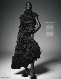 Black woman wearing a textured black ruffled gown and feathered heels against a gradient studio backdrop