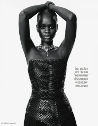 Model in strapless black textured bustier wearing layered necklaces against a white background