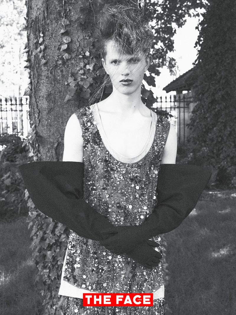 Model wearing a sequined top and exaggerated black flared gloves in front of a tree for The Face China.