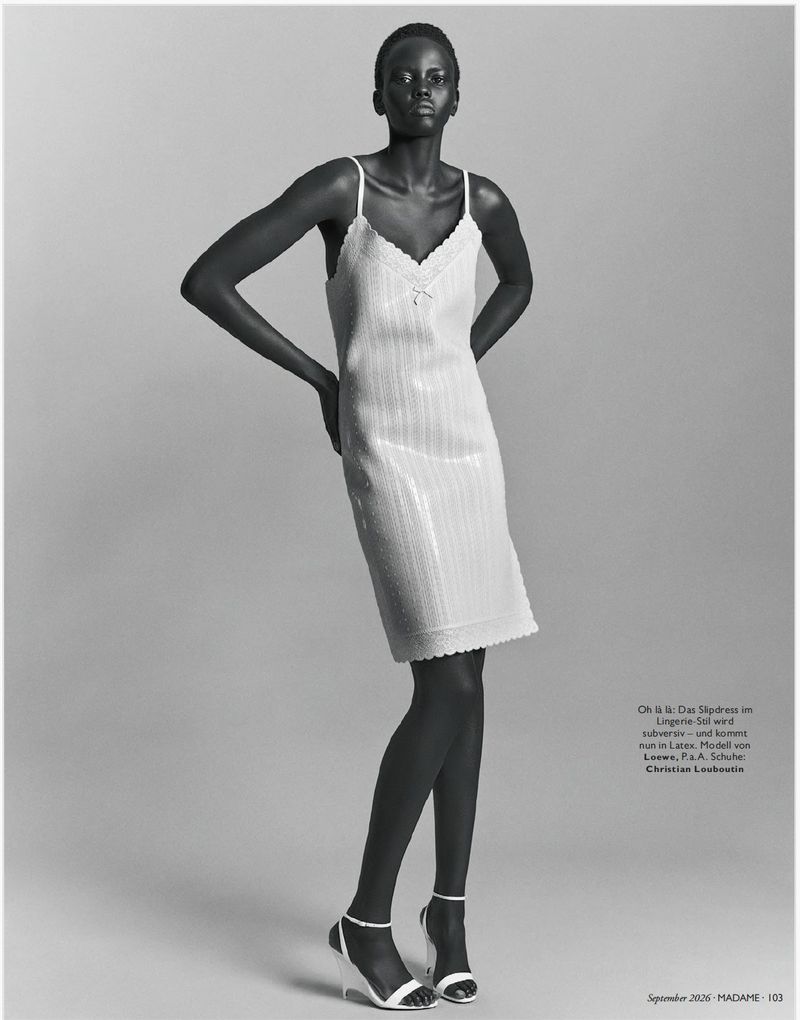 Model Ajak Dhieu wearing a textured slip dress and heels against a grey seamless background for Madame Germany