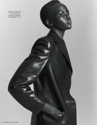 Model Ajak Dhieu posing in a tailored black leather blazer against a studio backdrop in a black and white profile portrait.