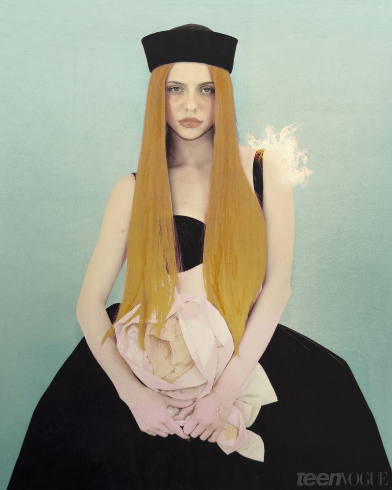 Adéla Jergová wearing a black sailor hat, black gown, and long straight orange hair against a teal background for Teen Vogue.