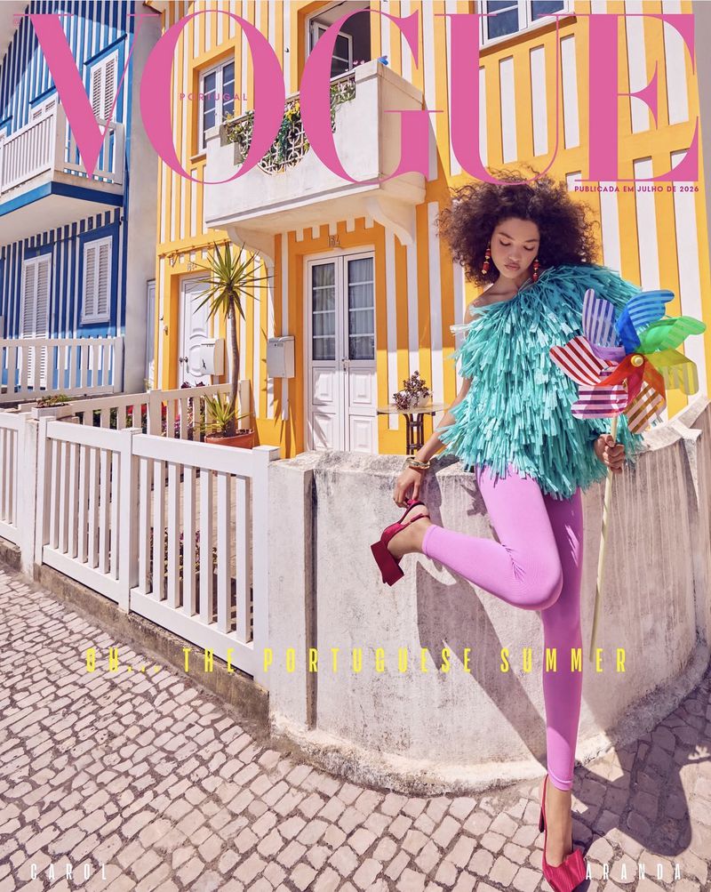 Model with voluminous curly hair wearing a turquoise fringe top and pink leggings holding a large colourful pinwheel
