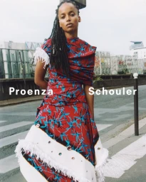 Model Mawena Takpa in a printed red and blue fringe dress on a city street for Proenza Schouler.