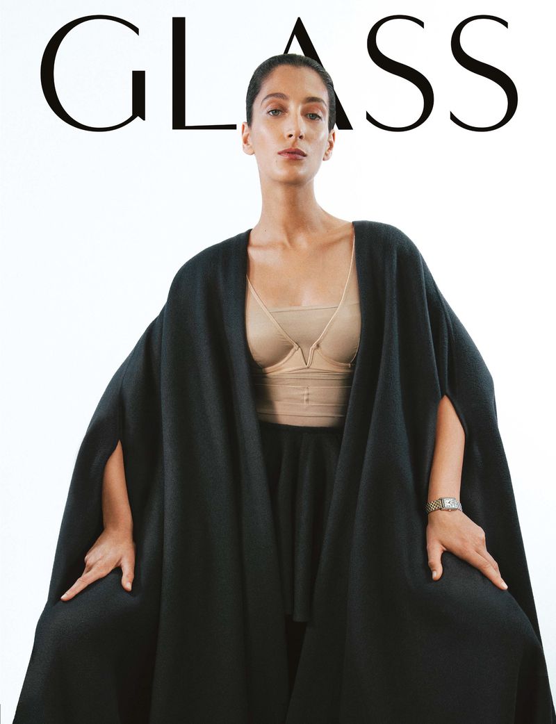 Magazine cover featuring a woman in a black cape and structured top against a white background with the word 'GLASS' at the top.