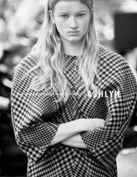 Monochrome portrait of a model with crossed arms wearing a structural gingham check top for Ashlyn.