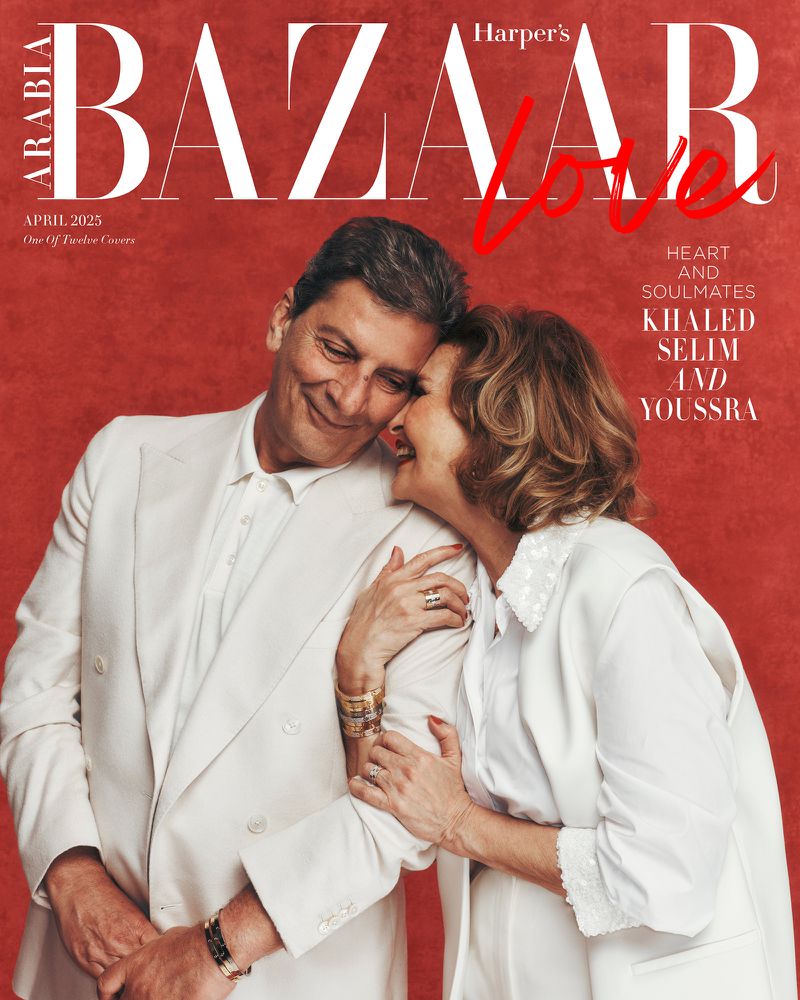 Magazine cover featuring a smiling adult couple in white attire, posing against a red background, with 'Harper's Bazaar' text.
