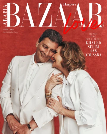 Magazine cover featuring a smiling adult couple in white attire, posing against a red background, with 'Harper's Bazaar' text.