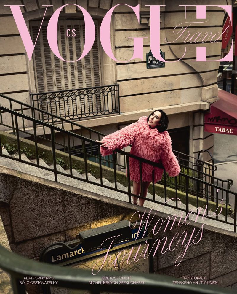 Vogue Travel cover featuring a woman in a pink faux fur coat on a staircase in Paris with the magazine logo and text overlay.