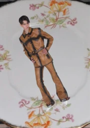 Fashion collage of a model wearing a belted tan leather suit positioned on an antique floral ceramic side plate.
