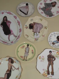 Arrangement of vintage floral porcelain plates featuring collaged fashion editorial images of models on a neutral beige background.