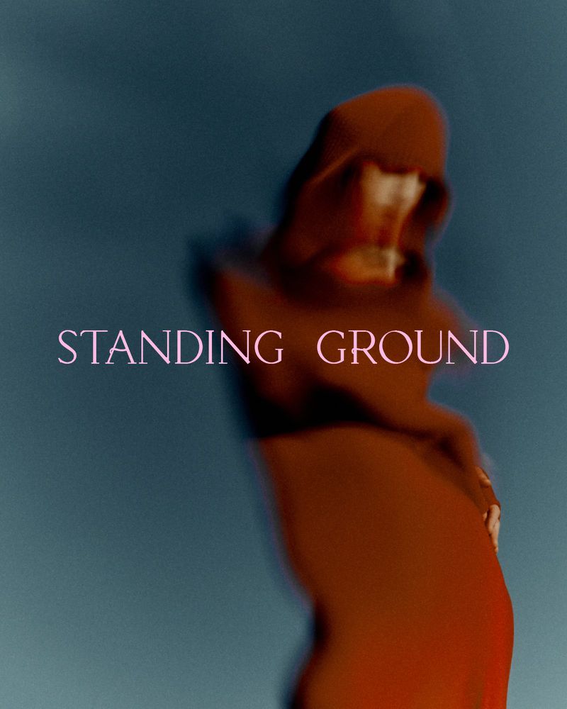 Abstract image featuring a blurred figure in a hooded garment against a dark blue background, with the text 'STANDING GROUND' visible.