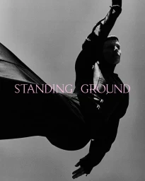 Model Saskia de Brauw captured in a dynamic black-and-white portrait with a flowing garment against a sky backdrop for Standing Ground.