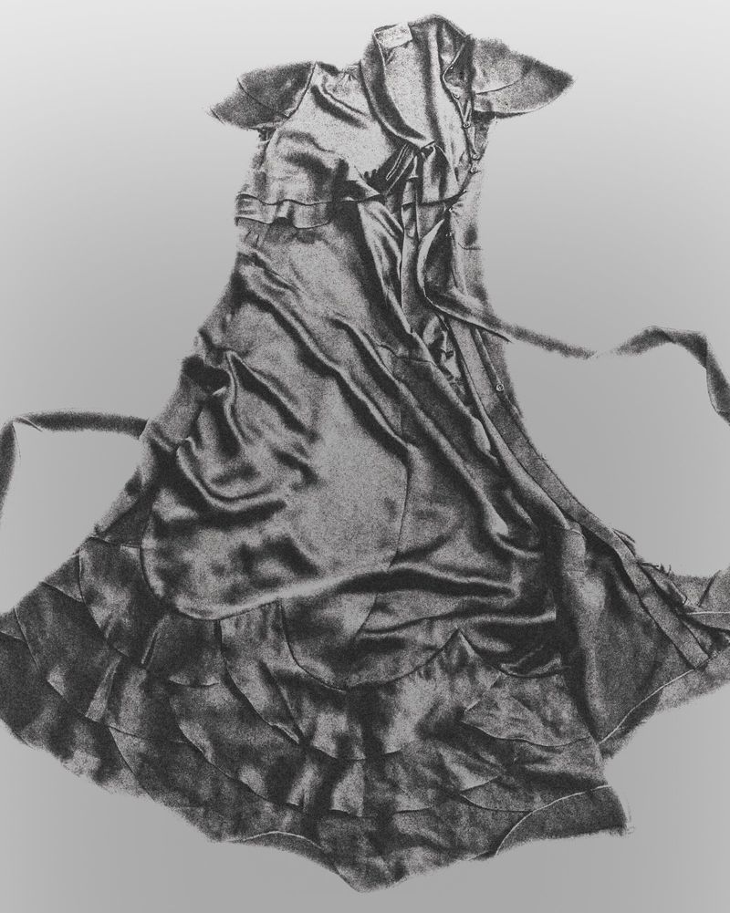Monochrome still life of a draped satin ruffled dress with short sleeves and tiered hem laid flat against a neutral background.