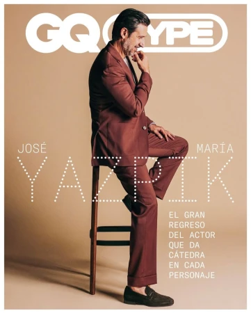 Magazine cover features a man in a suit sitting on a stool against a beige background with large typography and the GQ Type logo.