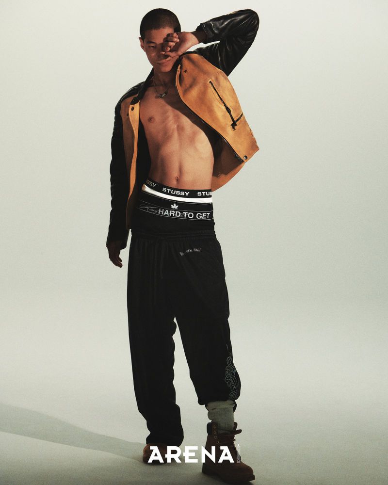 Model Bojvck Kang wearing an open two-tone jacket, layered waistband underwear, and black sweatpants against a studio backdrop.