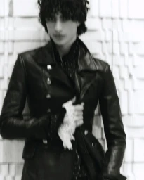 Model Yoesry Detre wearing a black leather jacket with a white lace cuff in a black and white editorial portrait.