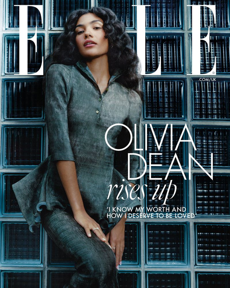 Magazine cover featuring Olivia Dean with an teal suit, standing against a teal glass block background. Elle magazine logo at top.