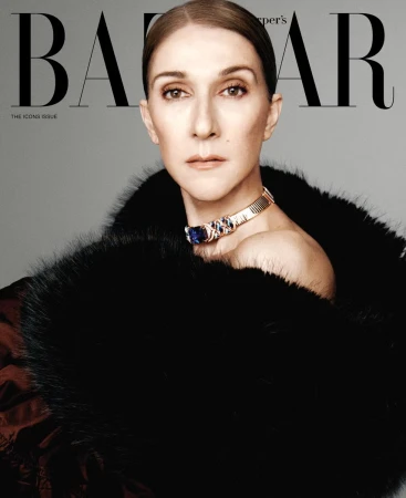 Celine Dion wearing a voluminous black fur wrap and a statement gold choker against a light grey studio background.