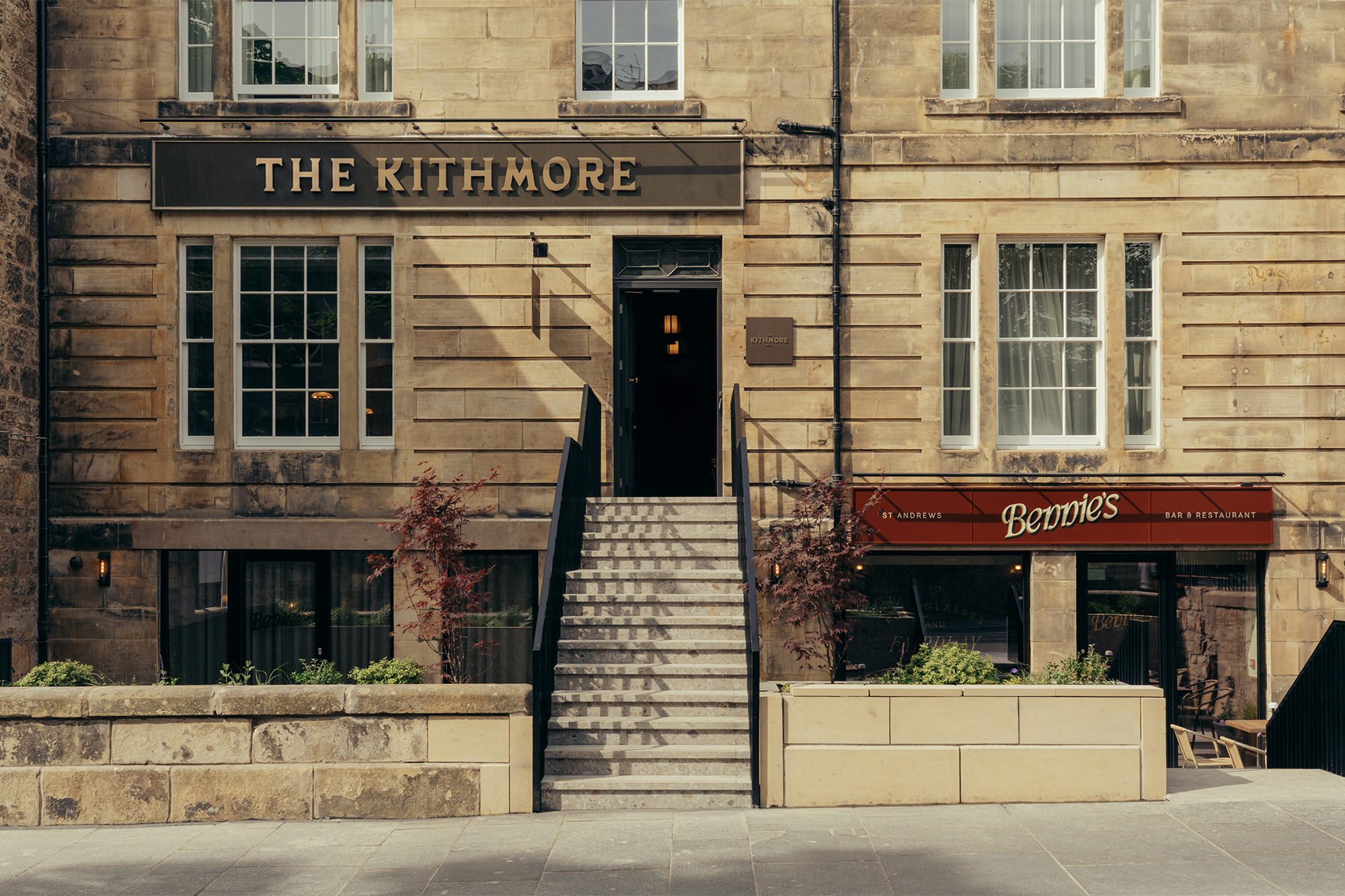 Sandstone exterior facade of The Kithmore hotel and Bennie's bar with central stone steps leading to an open entrance.