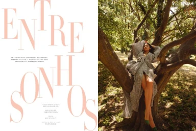 Model Raynara Negrine reclining among the branches of a large tree wearing a draped grey gown in a Harper's Bazaar Brazil spread.