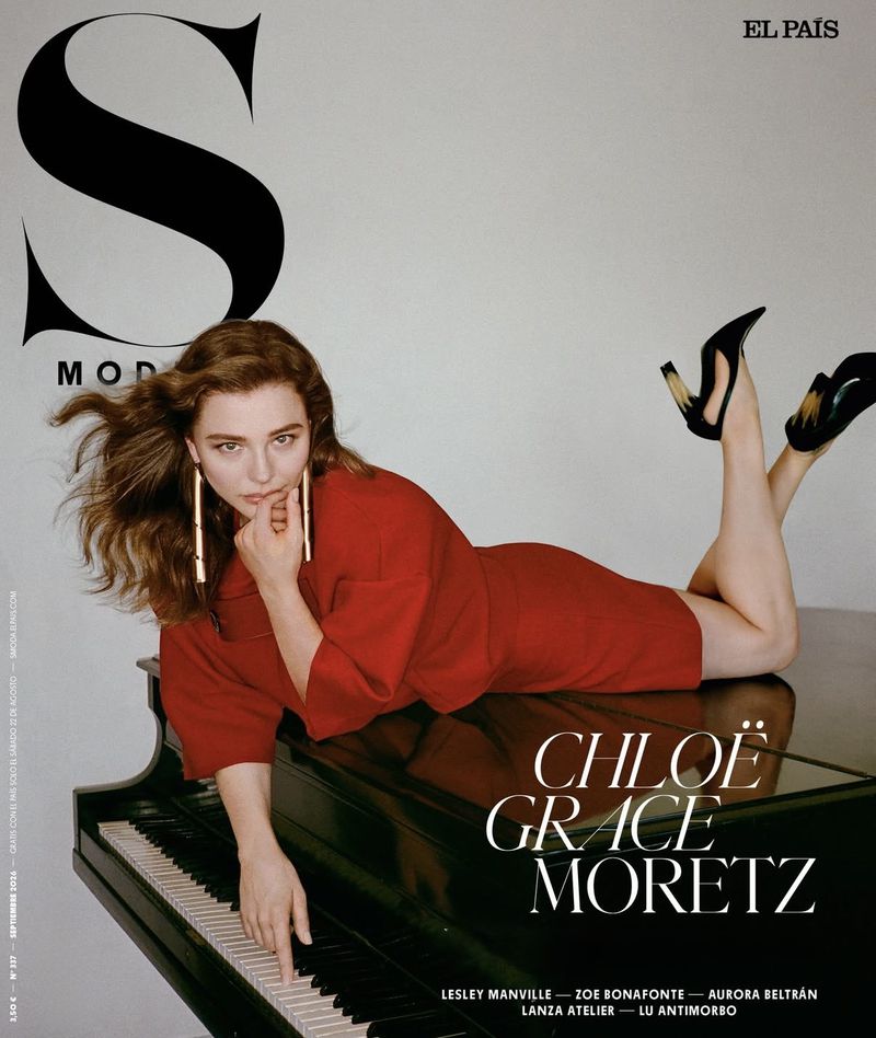 Chloë Grace Moretz wears a red dress while lying across a black grand piano in a studio editorial photograph for S Moda.