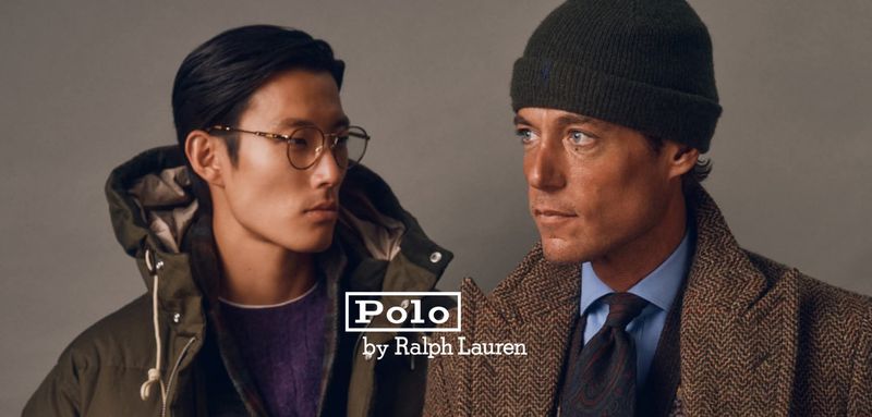 Two men wearing Polo Ralph Lauren fall menswear, including a green parka with glasses and a tweed coat with a knit beanie.
