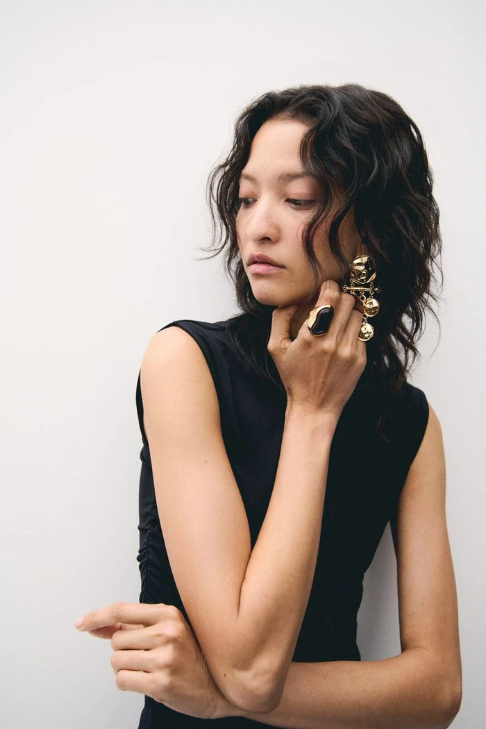 Model America Gonzalez wearing gold earrings and rings in an accessories campaign for H&M shot by Marius Uhlig.