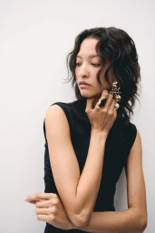 Model America Gonzalez wearing gold earrings and rings in an accessories campaign for H&M shot by Marius Uhlig.