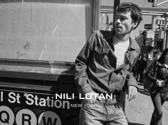 Model Luca Apple in a denim shirt and jeans leaning against a subway station entrance for Nili Lotan.