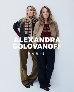Alexandra Golovanoff and Philippine Leroy-Beaulieu posing together in knitwear and tailored trousers against a white seamless backdrop.