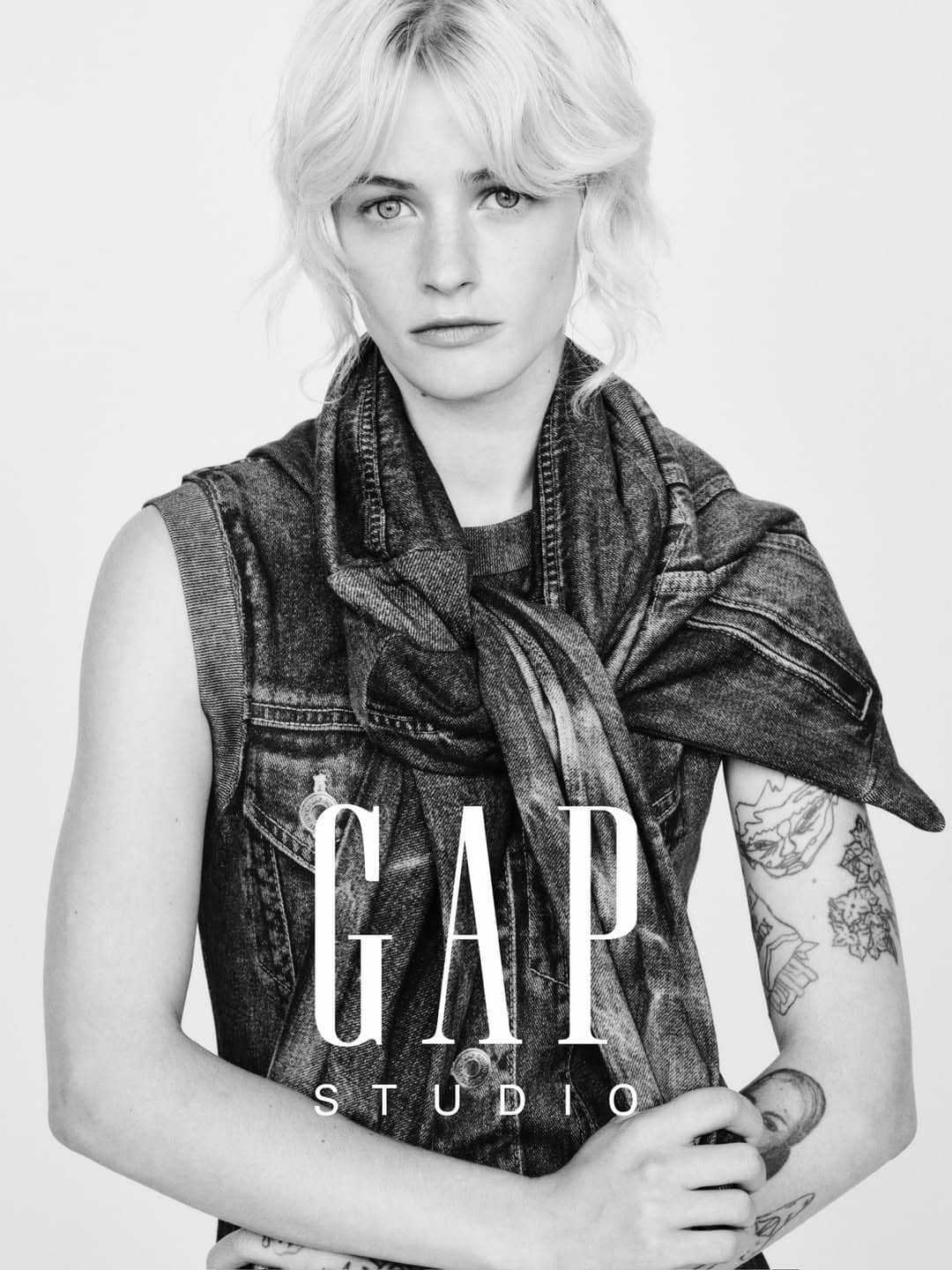 Esther Rose McGregor posing in a layered denim vest and scarf against a white studio background for Gap Studio.