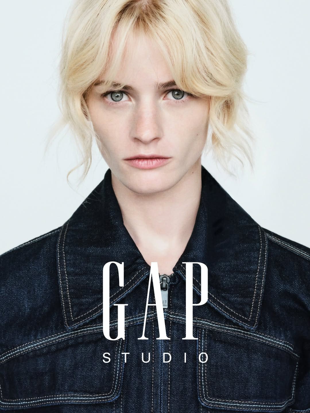Esther Rose McGregor wearing a dark denim jacket with white contrast stitching against a white backdrop for Gap Studio.