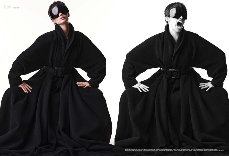 Two women in black robes and large visors pose against a white backdrop, one with a neutral expression and the other yelling.