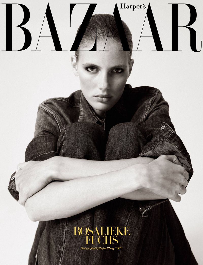 Model Rosalieke Fuchs seated in dark denim embracing her knees against a white backdrop for Harper's Bazaar.