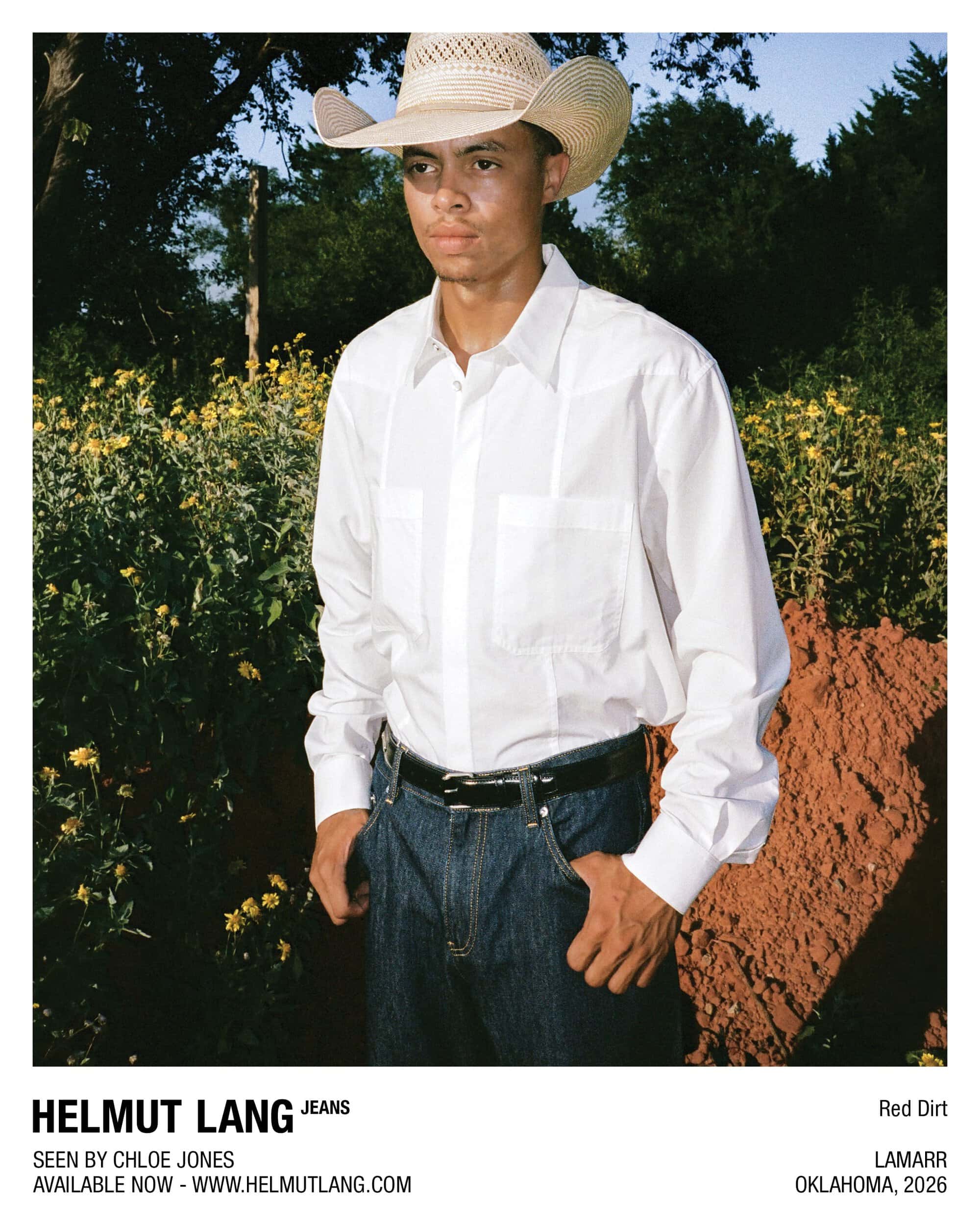 Man in a straw cowboy hat, white button-up shirt, and dark blue jeans outdoors for Helmut Lang Jeans.