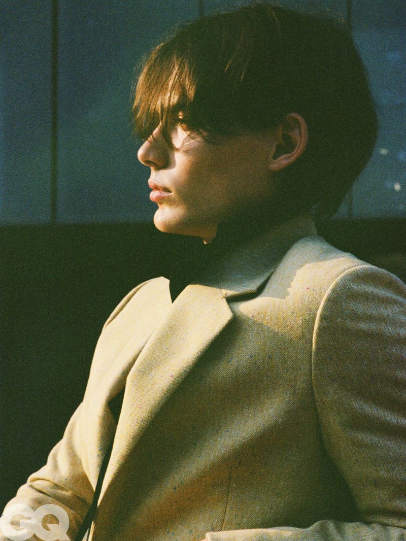 Model Meng Yu Qi in side profile wearing a textured beige blazer illuminated by direct warm sunlight for GQ China.