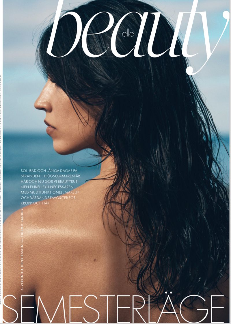 Magazine cover featuring an adult female model in profile with long dark hair, photographed outdoors with a view of the water.
