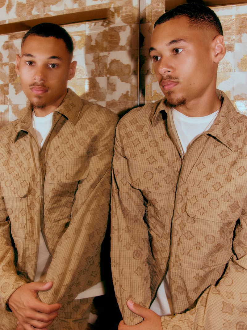 Eliyha Altena wearing a beige patterned jacket standing beside his mirror reflection for Marie Claire Belgium.