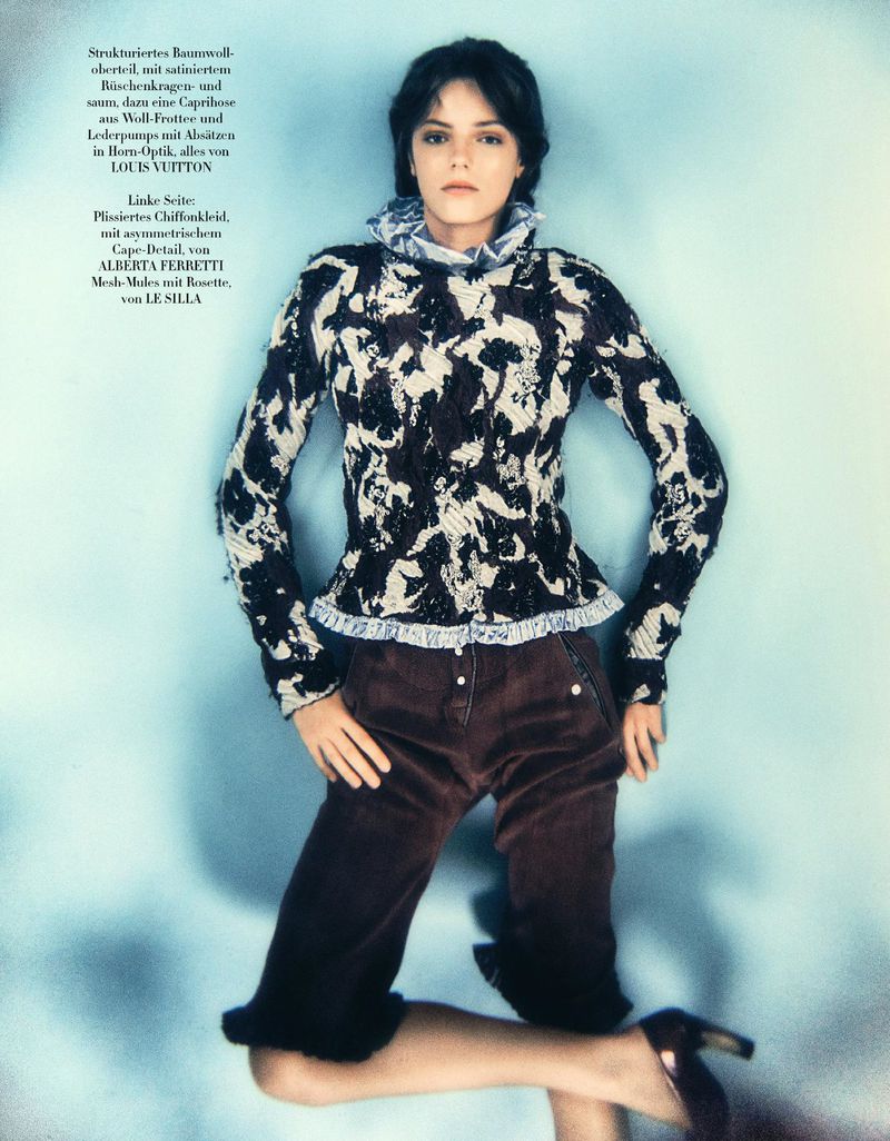 Matilde de Nard kneeling against a pale blue backdrop in a black and white ruffled top and dark brown capri pants.