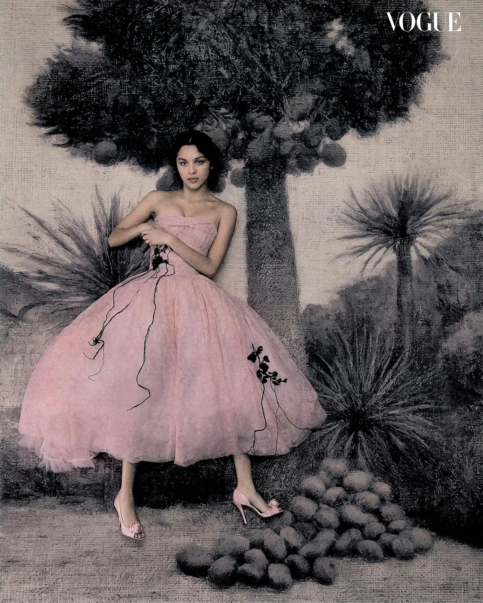 Olivia Rodrigo in a strapless pink tulle dress and matching heels posing against a painted tree backdrop.