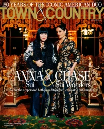 Anna Sui and Chase Sui Wonders posing in ornate metallic eveningwear inside a lavish gilded theater for Town and Country.