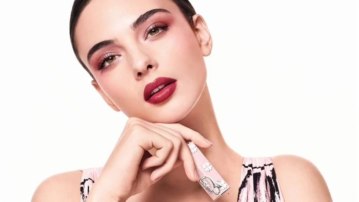 Deva Cassel holding a Dior lipstick against a clean white background in the Lucky Clover beauty campaign