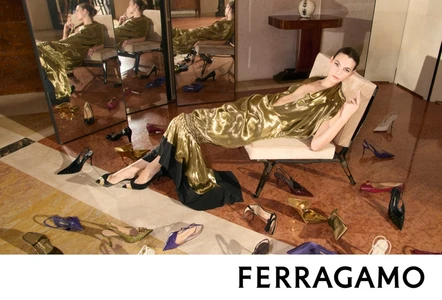 Model Vittoria Ceretti reclining in a gold and black gown on a chair surrounded by shoes in a Salvatore Ferragamo campaign image
