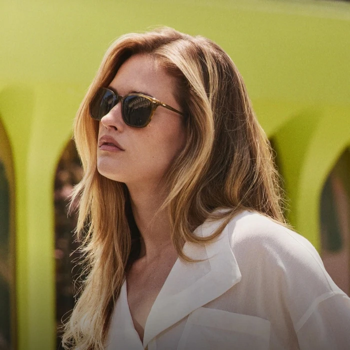 Hailey Carlson wearing sunglasses and a white shirt for Oliver Peoples photographed by Aaron Feaver.