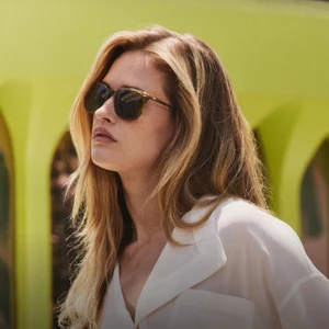 Hailey Carlson wearing sunglasses and a white shirt for Oliver Peoples photographed by Aaron Feaver.