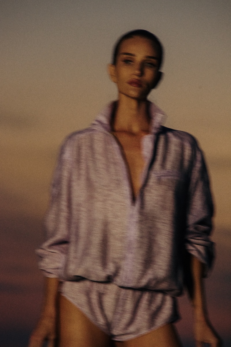 Rosie Huntington-Whiteley wearing a lavender zip pullover and shorts against a sunset sky for FWRD Summer 2026